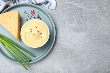 Wall Mural - Tasty cheese sauce with green onion and peppercorns on light grey table, top view. Space for text