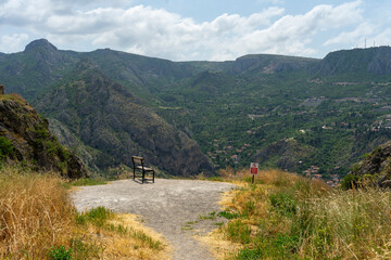 Bench with a view of the city below from the top of the mountain