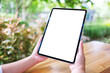 © Farknot Architect - Mockup image of a woman holding digital tablet with blank white desktop screen in the outdoors