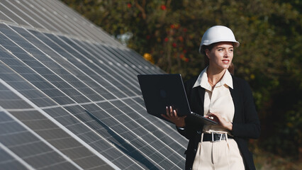 Wall Mural - Solar panels and investor with laptop. Business woman with laptop near solar panels. Green energy for home and business