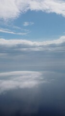 Wall Mural - aerial view. blue sky sun and fog over calm sea. the drone flies over foggy and fluffy clouds. abstr