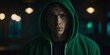 © Den Boro Day - A young man with a green hoodie and black shirt is standing in a dark room.