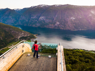 Wall Mural - Tourist enjoying fjord view on Stegastein viewpoint Norway