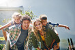© AK Coop/peopleimages.com - Happy, parents portrait and piggyback with children for bonding, holiday or weekend in backyard at home. Mother, father and kids with smile for hug, support or love for playful outdoor day together