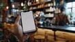 © Karaket - Close up of a man hand holding a smartphone in a cafe
