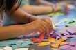 © Nico - A close-up of a students hands carefully cutting paper shapes for a craft project