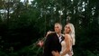 © Ruslan - Young wedding couple hugging. The groom hugs the bride in nature, against the backdrop of the forest.