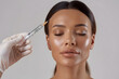 © StockLab - Woman with syringe on a light background