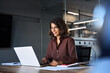 © Stock 4 You - Smiling 30s latin hispanic middle-aged business woman working on laptop computer in modern office. Indian young businesswoman professional employee using pc doing online banking analysing at workplace