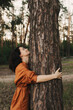 © Forewer - Happy adult lady hug tree trunk in outdoor leisure park activity. Concept of environment and ambient nature care. People love planet earth and stop deforestation lifestyle