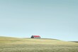 © ChaoticMind - A lone farmhouse with a red roof stands isolated on a vast, empty field under a clear blue sky, portraying a calm and peaceful rural landscape devoid of any modern distractions.