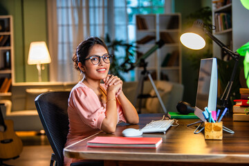 Wall Mural - Indian asian  young student or businesswoman using laptop with coffee, books, smartphone, headphone