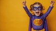 © KADER - High Resolution Photo of Happy Child in Purple Superhero Costume Against Yellow Background, Celebrating with Arms Raised and Mouth Open Wide