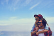 © JordaanExams/peopleimages.com - Couple, smile and piggyback holiday or blue sky, happy and relationship bonding on weekend break with love. Summer, commitment and outdoor space on nature date together, support and young people
