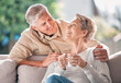 © Oostendorp/peopleimages.com - Senior, couple and coffee with love on sofa in morning, happiness and hug or lounge with care for marriage. Mature, man and woman with warm beverage in family house, bonding and relationship.