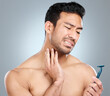 © peopleimages.com - Model, face and neck shaving injury with self care grooming, health or beard mistake. Pain, man and hair removal accident with cleaning, facial treatment and razor on gray studio background