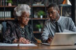 © MarGa - Elderly african american woman and young african american man working together at a desk. Concept for teamwork, business collaboration, and professional support, fitting for office and mentorship scen