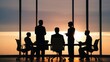 © Thanapol - Silhouettes of Business Professionals in a Modern Office Meeting at Sunset