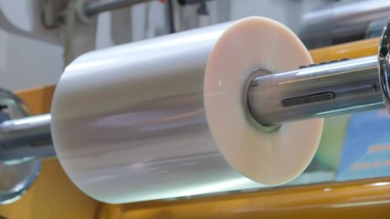 Poster - Automatic polyethylene plastic bag production machine with lighting effect. Close-up of the roller of the plastic bag production machine in the light. product packaging concept