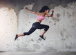 © peopleimages.com - Sports, running and woman with speed in city for workout, marathon training or endurance challenge. Fitness, wellness and hispanic athlete with jump for morning cardio, energy or race in urban town
