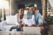 © JorSons/peopleimages.com - Couple, laptop and happy with paperwork for finance on sofa with planning taxes or success with loan application. Black people, technology and documents for mortgage contract and insurance investment