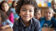 © Ananncee Media - A young boy sits in a classroom and smiles at the camera
