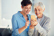 © Leffy/peopleimages.com - Happy, phone and woman with senior mom for picture memory, social media and helping with app in home. Elderly mother, daughter and mobile for web blog, online photo gallery and bonding time together