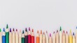 © TheWaterMeloonProjec - Row of assorted colored wooden pencil crayons in line on white backdrop