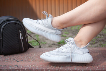 A girl in sports shoes rests in nature, health and sports.