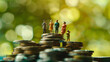 © Mahemud - Miniature people standing on a pile of coins, symbolizing inequality and social class disparities. Illustrates concepts related to income inequality, social ideologies.