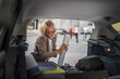 © Miljan Živković - mature blonde woman travel take stuff belongings from the back of car