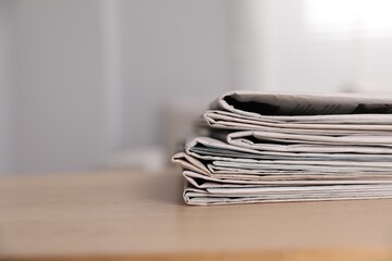 Canvas Print - Stack of newspapers in different languages on table indoors. Space for text