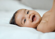 © KayJoint/peopleimages.com - Baby, portrait and smile on bed in home for child care, wellness and relax with peace, calm and health. Newborn, face and young girl in bedroom of house in morning for growth, development and happy