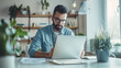 © Tanayut - Focused man working on laptop in a home office surrounded by plants