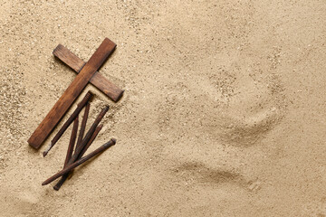 Sticker - Wooden cross with nails on sand. Good Friday concept