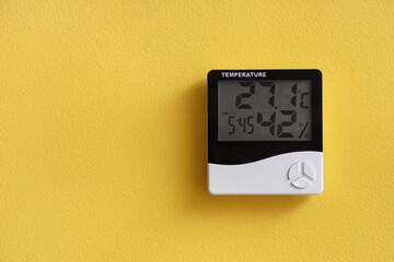 Digital hygrometer on yellow wall