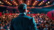 © EmmaStock - A man stands in front of a crowd of people, giving a speech