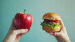 © Yuliia Litvinova - One hand holds a fresh apple, while the other holds a hamburger, contrasting healthy organic vegetarian food with unhealthy processed fast food, highlighting a choice in nutrition and lifestyle.