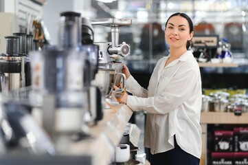 Wall Mural - Woman choosing kitchen equipments at store