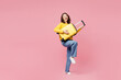 © ViDi Studio - Traveler fun woman wear yellow casual clothes hold bag pov play guitar isolated on plain pastel pink background. Tourist travel abroad in free spare time rest getaway. Air flight trip journey concept.