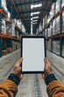 © Ева Поликарпова - A worker holds a tablet in a modern warehouse setting