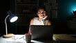 © Krakenimages.com - Pensive young woman working late on laptop in dark office illuminated by desk lamp