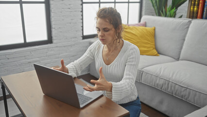 Sticker - A frustrated young woman using a laptop in a modern living room.