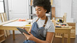 © Krakenimages.com - African american woman using a tablet in a carpentry workshop, reflecting professionalism and concentration.