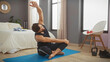 © Krakenimages.com - Man stretching on a yoga mat in a modern bedroom interior, promoting wellness and an active lifestyle at home.