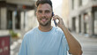 © Krakenimages.com - Handsome young hispanic man with beard talking on phone on a city street.