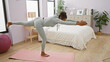 © Krakenimages.com - African woman practicing yoga in a modern bedroom setting, showcasing balance and wellness indoors.