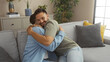© Krakenimages.com - Men embracing lovingly on a cozy sofa, highlighting gay couple in a warm, indoor home environment filled with plants and decor, showcasing family love and emotional connection.