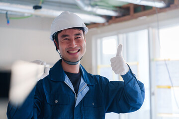 Wall Mural - 建設現場で資材を運ぶ男性の職人