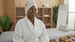 © Krakenimages.com - Woman smiling in a spa room with towels, plants, and decor, capturing a serene and relaxing atmosphere.